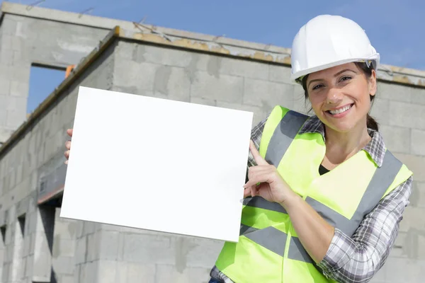 持白色广告横幅的女建筑工人 — 图库照片