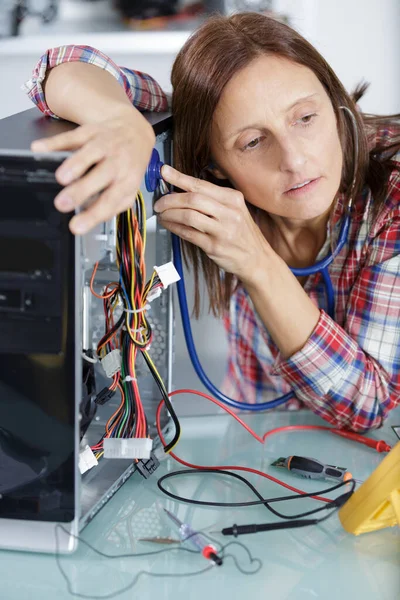 聴診器を使ってパソコンを修理する女性は — ストック写真