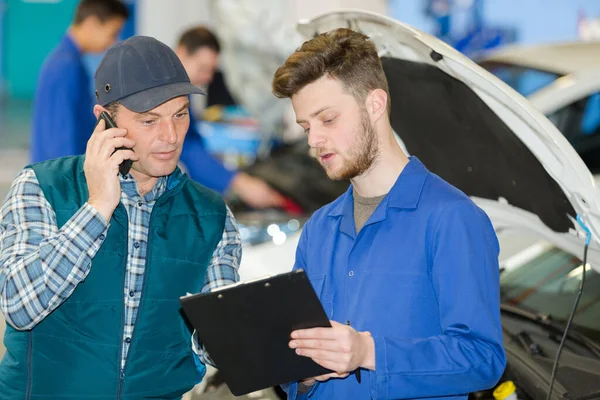 Apprendista Meccanico Parlando Con Uomo Utilizzando Smartphone — Foto Stock