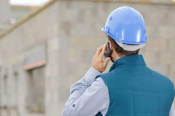 Man Byggmästare Byggarbetsplatsen Med Hjälp Telefon Och Planer — Stockfoto