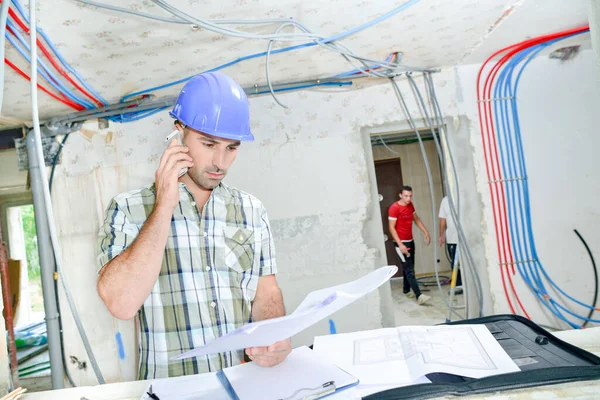 Worker Phoning Examining Sketches — Stock Photo, Image