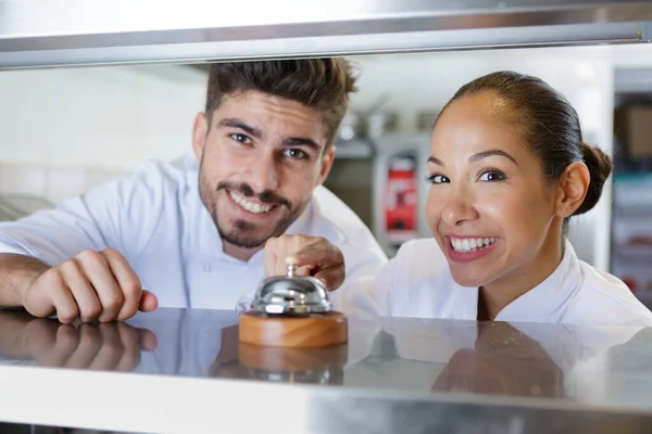 Restaurantchef Lächelt Und Zeigt Auf Küchenglocke — Stockfoto