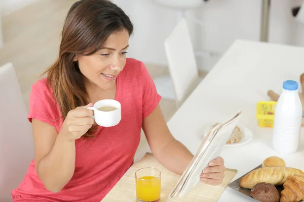 Donna Che Legge Giornale Mentre Mangia Colazione Casa — Foto Stock