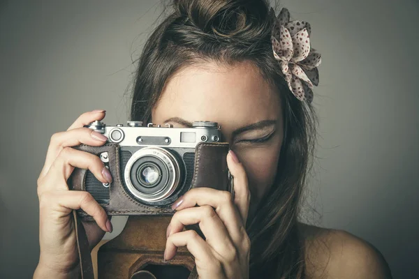 Молода жінка робить фотографії з старовинною камерою — стокове фото