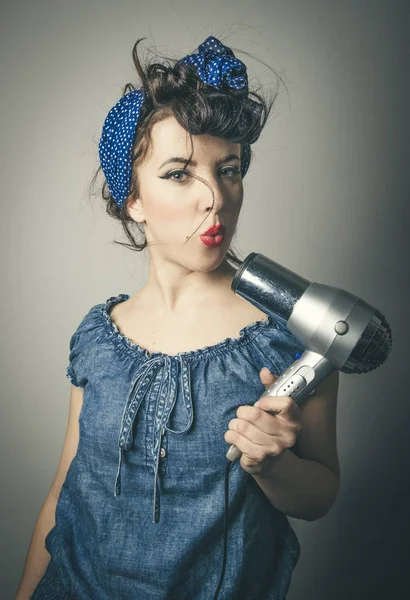 Huisvrouw in vintage kleding met een föhn — Stockfoto