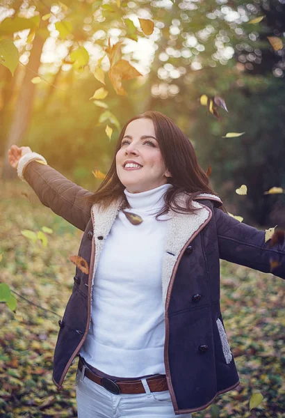 Feliz joven jugando con hojas de otoño — Foto de Stock