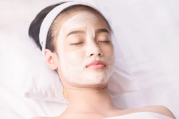 Gadis muda dengan masker wajah di salon kecantikan — Stok Foto