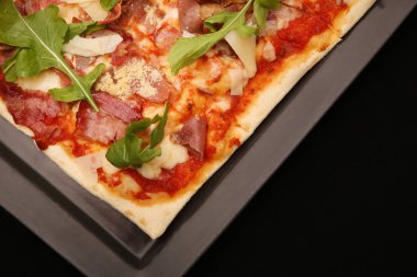 Siyah arka planda pizza.