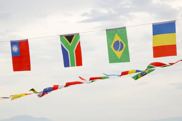Many different flags against blue sky