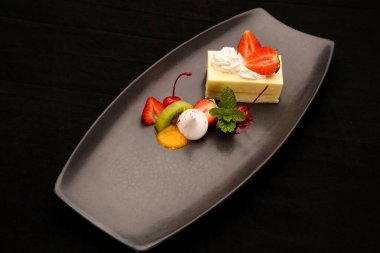 Çilekli cheesecake meyve ve vanilyalı dondurma ile servis
