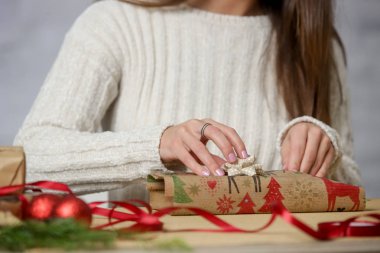 Noel hediyelerini paketleyen kadın, kış tatilleri, hediye sezonu konsepti.