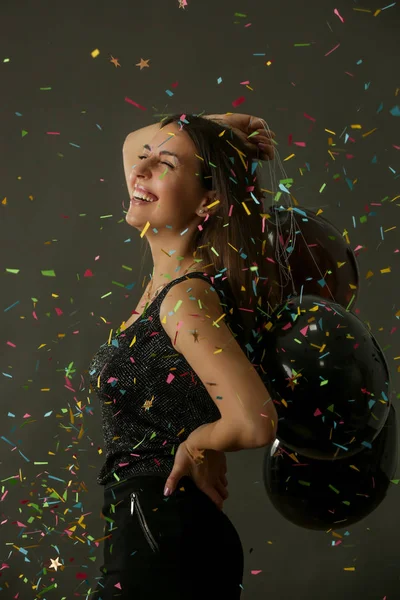 Aantrekkelijke Vrouw Met Zwarte Ballonnen Dansen Onder Vallende Confetti Feest — Stockfoto