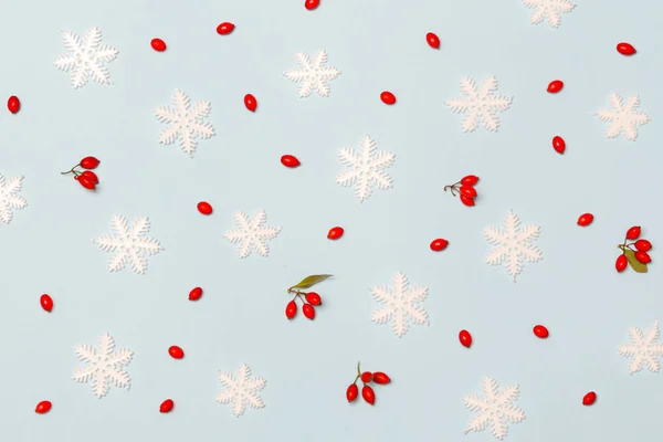 淡いブルーの背景に雪片と赤い果実で作られたクリスマスパターン クリスマス 冬の休日 新年のコンセプト — ストック写真