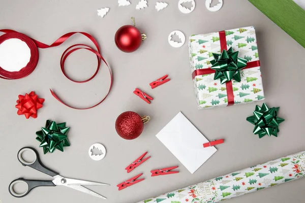 Wrapping Christmas gift on the table, directly above view on wrapping paper, bows and ribbons, decorative items for wrapping gift boxes