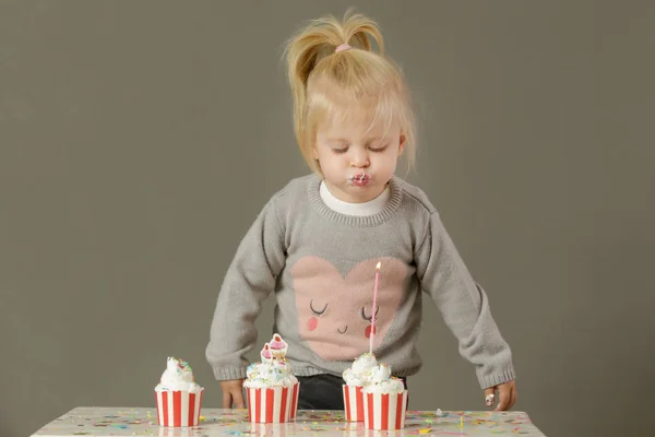 Studioaufnahme Eines Kleinkindes Das Eine Geburtstagskerze Von Einem Cupcake Pustet — Stockfoto