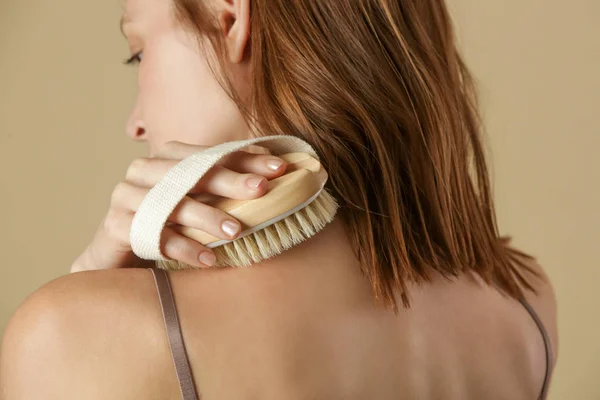 Kuru vücut fırçası, selüliti azaltmak, lenf sistemini detokse etmek ve güzel pürüzsüz bir cilt elde etmek için vücudunu kurutan kadın. Sabah sağlık ve enerji rutininin bir parçası olarak kuru cilt fırçalama.