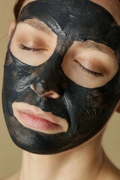 炭面マスクや黒い粘土泥 顔に黒いマスクの美しい女性は スタジオヘッドショットを閉じます 天然化粧品のコンセプト — ストック写真