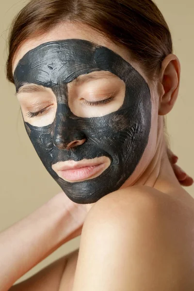 焦炭面罩或黑色粘土泥 漂亮的女人 脸上戴着黑色面具 近距离拍摄工作室的头像 天然化妆品概念 — 图库照片
