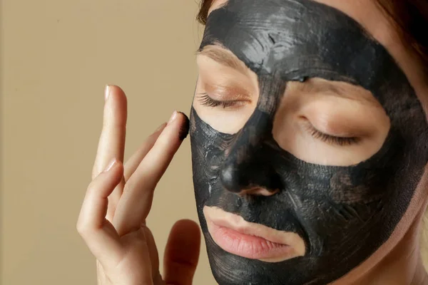 焦炭面罩或黑色粘土泥 漂亮的女人 脸上戴着黑色面具 近距离拍摄工作室的头像 天然化妆品概念 — 图库照片
