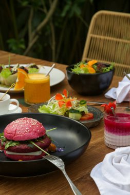 Tahta masada çeşitli sağlıklı vejetaryen yemekleri servis ediliyor.