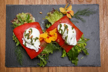 Açık yüzlü sandviç, ızgara biberli mısır ekmeği ve marul yatağında haşlanmış yumurta..