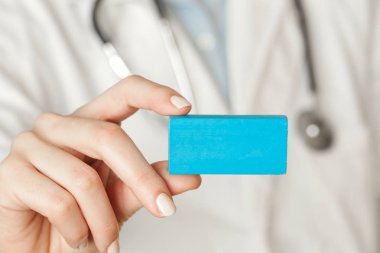 Tıbbî çalışanın elinde boş kart, sağlık ve tıp konseptini fotokopi alanı ile kapatma görüntüsü