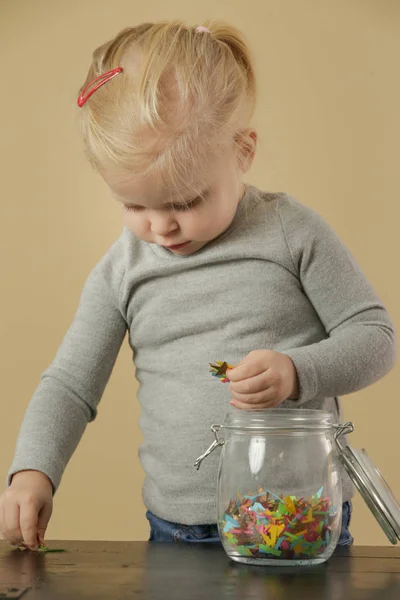 Schattig Peuter Meisje Spelen Met Een Pot Vol Confetti — Stockfoto