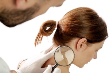 Dermatolog büyüteçle beni kontrol ediyor.