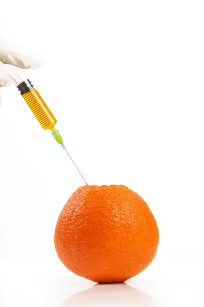 Closeup of needle injected into orange, Genetically engineered food concept