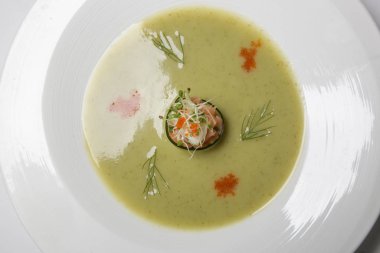 Somon tartarlı soğuk salatalık çorbası. Enfes bir yemek. Yaratıcı restoran yemeği konsepti.