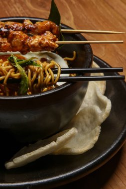 Kızarmış yumurtalı şehriye ve tavuk satay ile servis edilen sebze. Yaratıcı restoran yemeği konsepti.