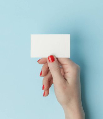 Woman hands holding blank card on blue table