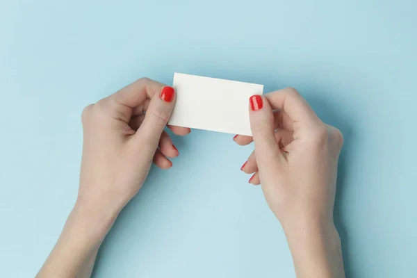 Mãos Mulher Segurando Cartão Branco Mesa Azul — Fotografia de Stock