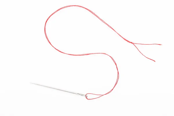 白い背景に赤い糸で針を縫う — ストック写真