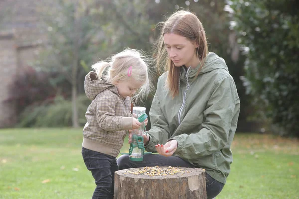 Mother Her Toddler Girl Putting Seeds Birds Bird Feeder Quality — Stock Photo, Image