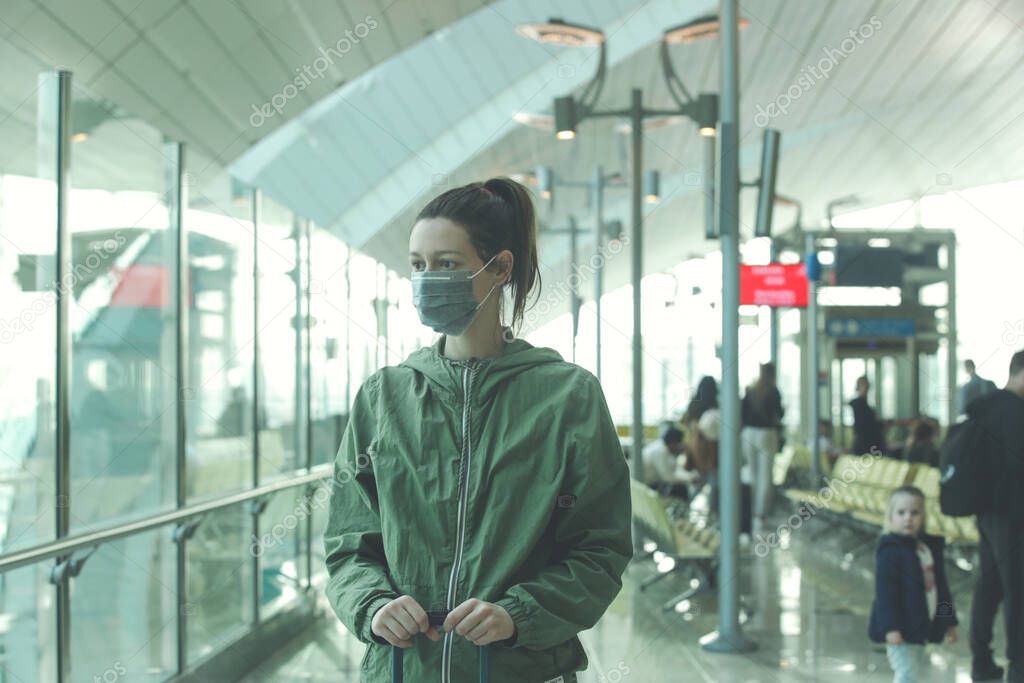 Woman wearing protective mask in airport, Coronavirus contagion fears concept
