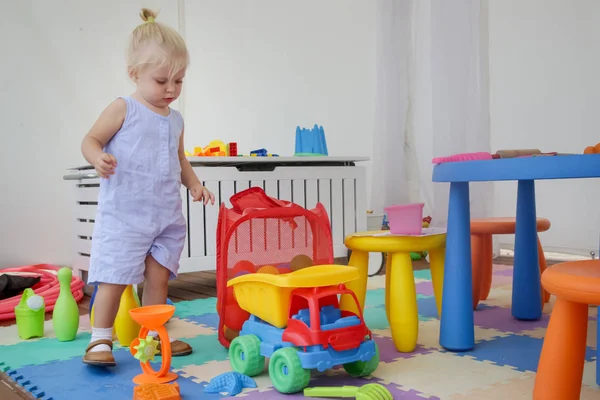 快乐的女婴在游戏室玩玩具 两岁的女婴在日托室 — 图库照片
