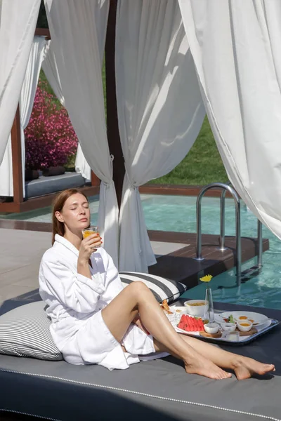 Woman Enjoying Breakfast Outdoor Daybed Side Curtains Next Swimming Pool — 스톡 사진
