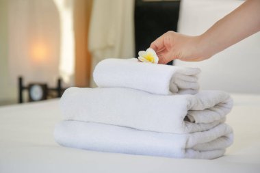 Oda servisi. Otel odasında havlu değiştiren kadın. Housecleaner yatağa havlu koyarak, müşterilerin taşınması için her şeyi hazırlanıyor