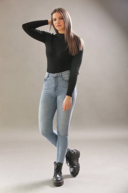 Siyah balıkçı yakalı genç esmerin portresi. Genç ve güzel bir kadının stüdyo çekimi..