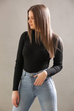 Siyah balıkçı yakalı genç esmerin portresi. Genç ve güzel bir kadının stüdyo çekimi..