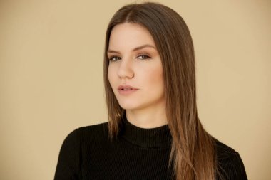 Siyah balıkçı yakalı genç esmerin portresi. Genç ve güzel bir kadının stüdyo çekimi..