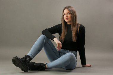 Siyah balıkçı yakalı genç esmerin portresi. Genç ve güzel bir kadının stüdyo çekimi..