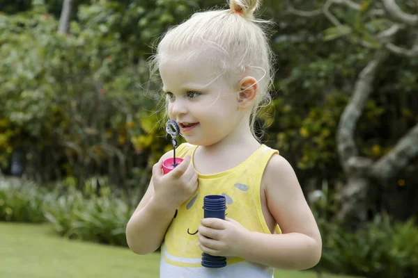 Menina Pequena Feliz Soprando Bolhas Sabão Parque — Fotografia de Stock