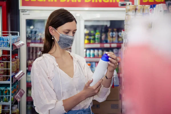 在超市购物时戴着防护面具的女人 科罗纳韦病毒会传染恐惧的概念 — 图库照片