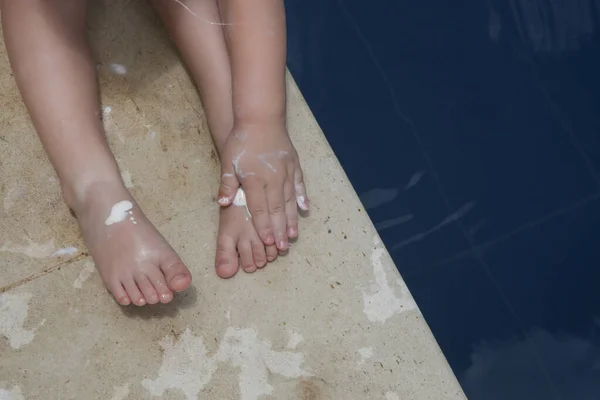 Linda Niña Pequeña Aplicando Crema Protección Solar Sus Piernas Loción —  Fotos de Stock