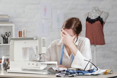 Uykulu, sinirli, yorgun terzi. Çalışma masasında baş ağrısı var. Küçük işletme ya da serbest meslek sorunları. Son teslim tarihi ya da aşırı çalışma kavramı, yaratıcı sektörde sıkılmaktan ya da yorulmaktan.