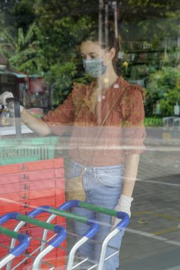 Süpermarkette alışveriş yaparken koruyucu maske takan kadın, Coronavirus salgını konseptinden korkuyor