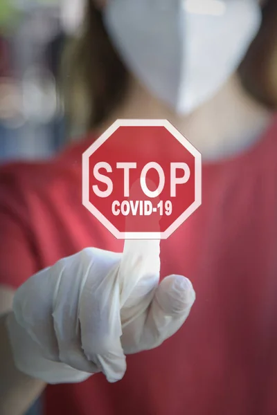 Woman in protective latex gloves and medical mask pressing Stop Corona Virus Sign.