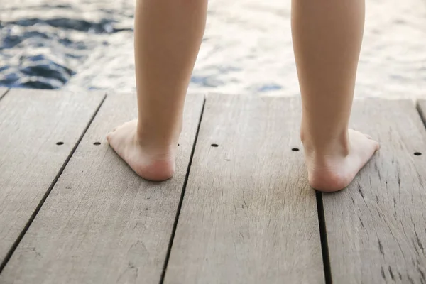 木の床に立つ裸足の幼児の足 — ストック写真